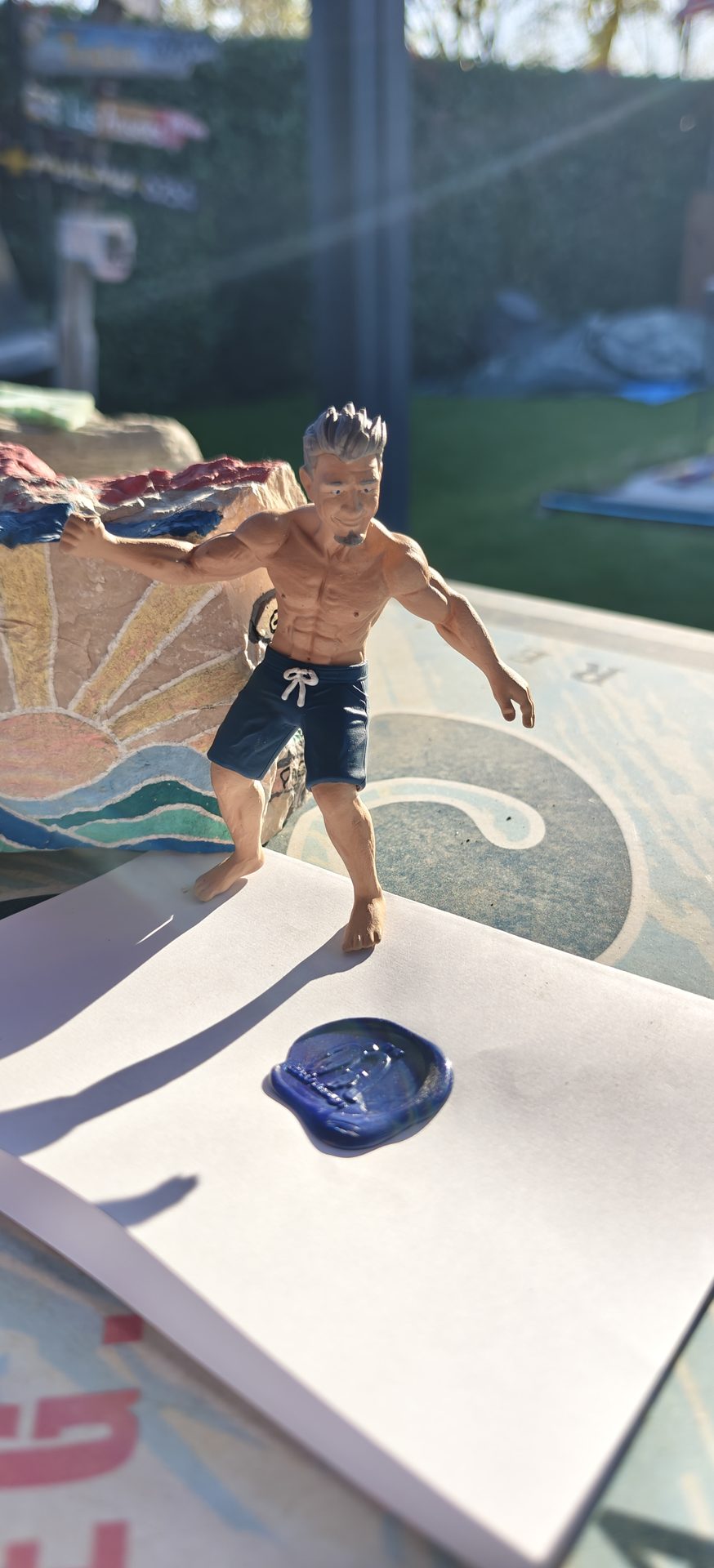 Teilbemalte Figur mit Kite im Hintergrund und Zertifikat